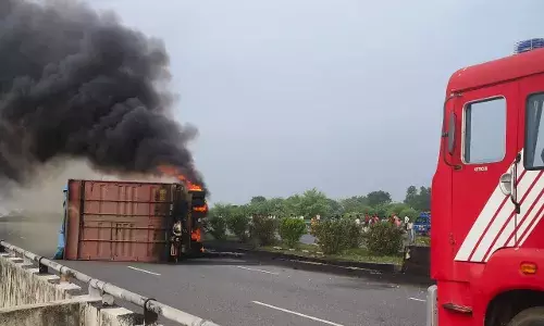 हाइवे पर दौड़ते कंटेनर में लगी आग देखकर घबराया चालक, हड़बड़ाहट में पल्टा कंटेनर, लाखों का कपड़ा खाक