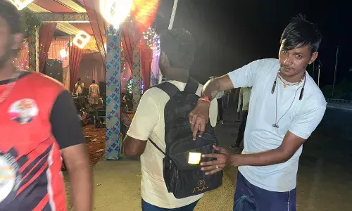 पदयात्रियों के बैग और हाथों में बांधी रेडियम पट्टियाँ