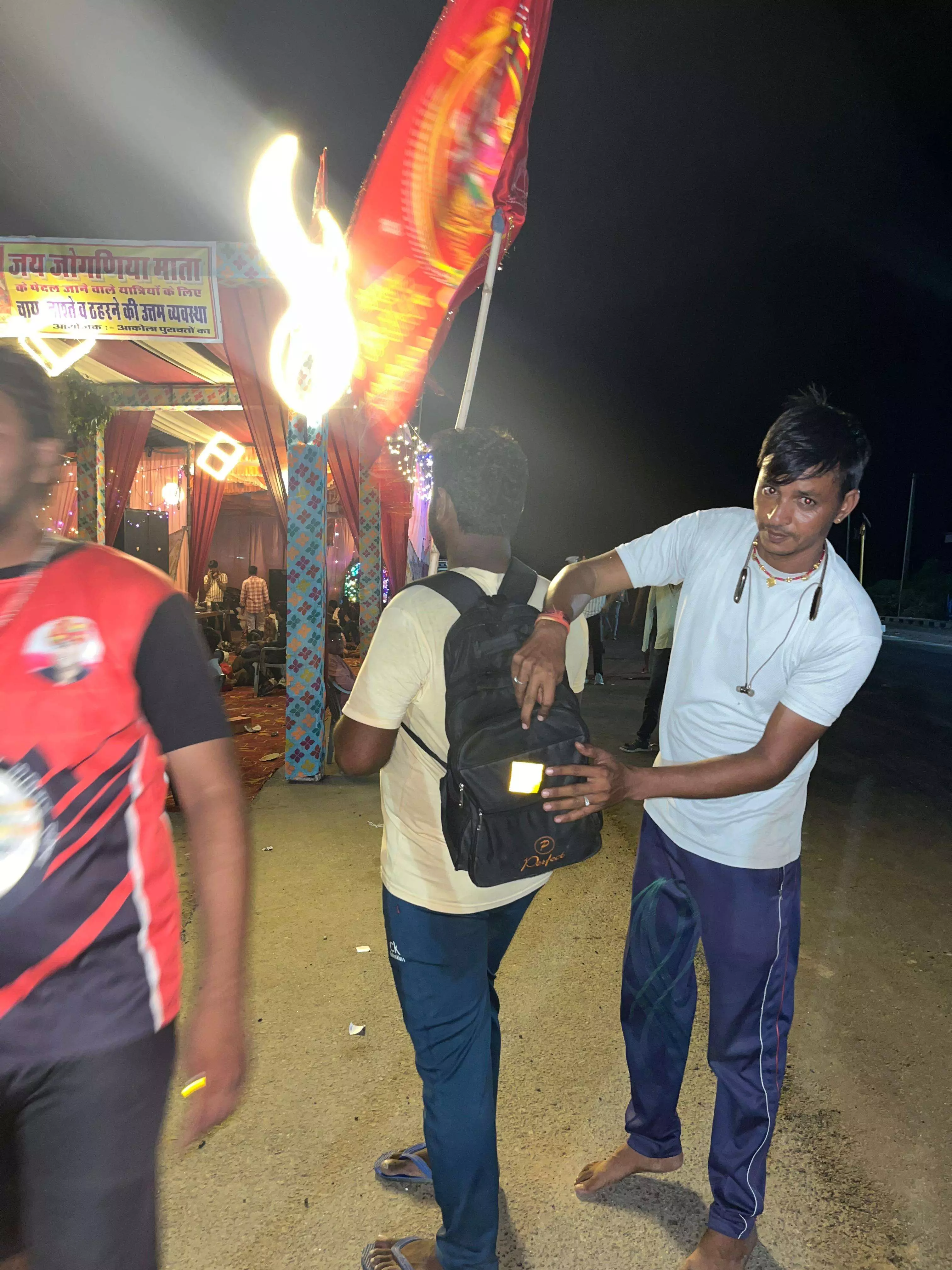 पदयात्रियों के बैग और हाथों में बांधी रेडियम पट्टियाँ