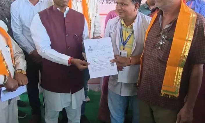 सफलता कि कहानी ग्रामीण सेवा शिविर बड़गांव में पाॅलिसी वितरण करते डॉक्टर मन्नालाल रावत