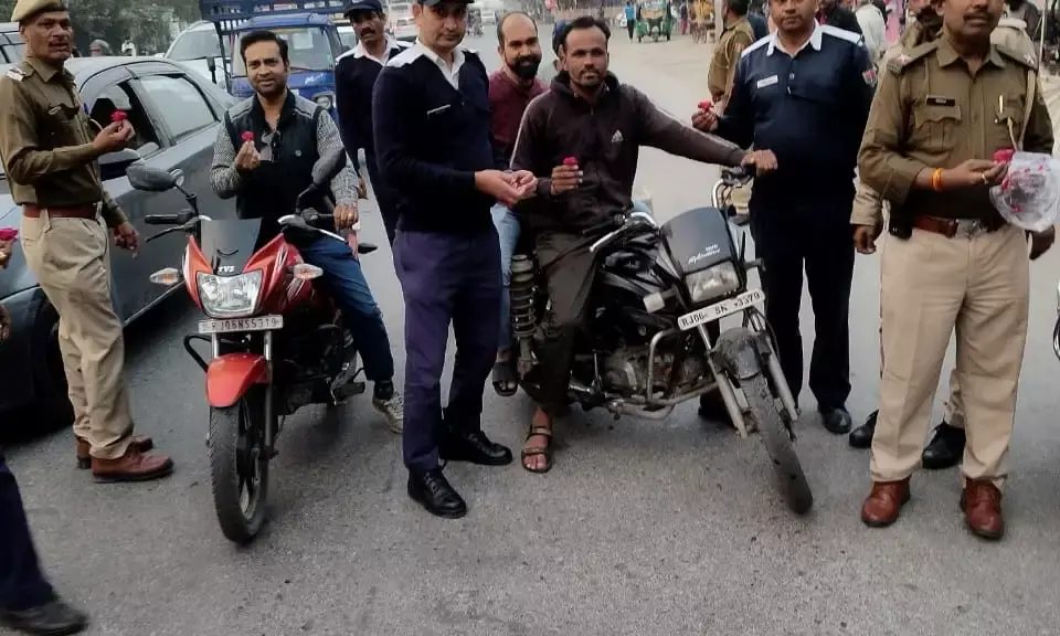 हेलमेट व सीट बेल्ट लगाने के लिए वाहन चालकों को गुलाब देकर किया जागरुक