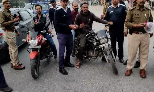 हेलमेट व सीट बेल्ट लगाने के लिए वाहन चालकों को गुलाब देकर किया जागरुक