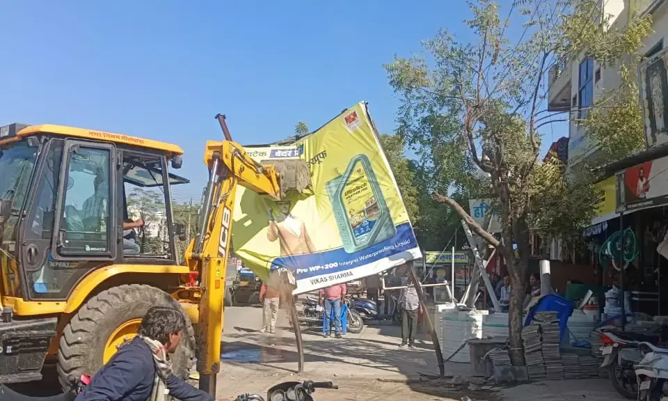 नगर निगम की टीम ने अवैध होर्ड‍िंग हटाने की कार्रवाई की